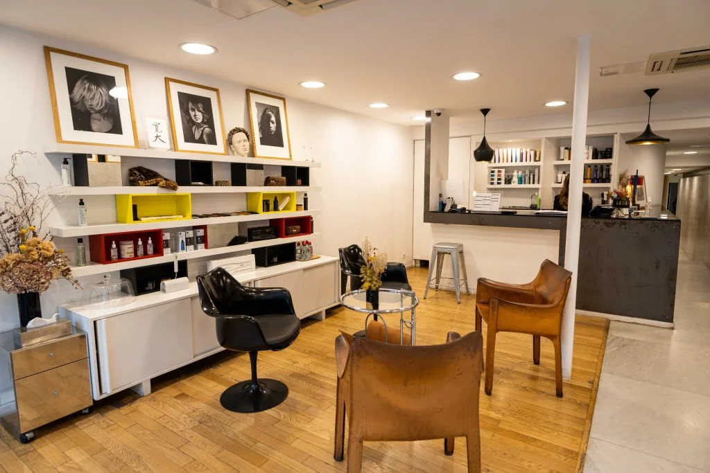 Paris 6 chez Massato coiffeur. Nous voyons 4 siège en cuir marrons dans la salle d'attente lumineuse.
