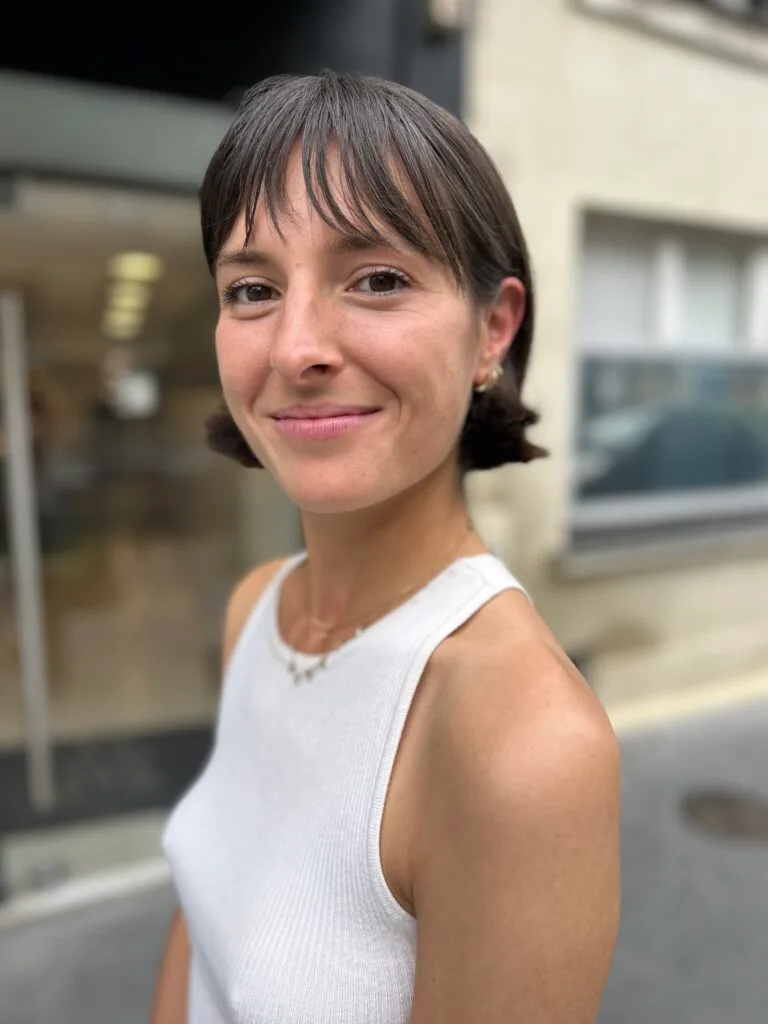 Jeune femme au cheveux brun arborant une coupe bob avec micro frange wet look