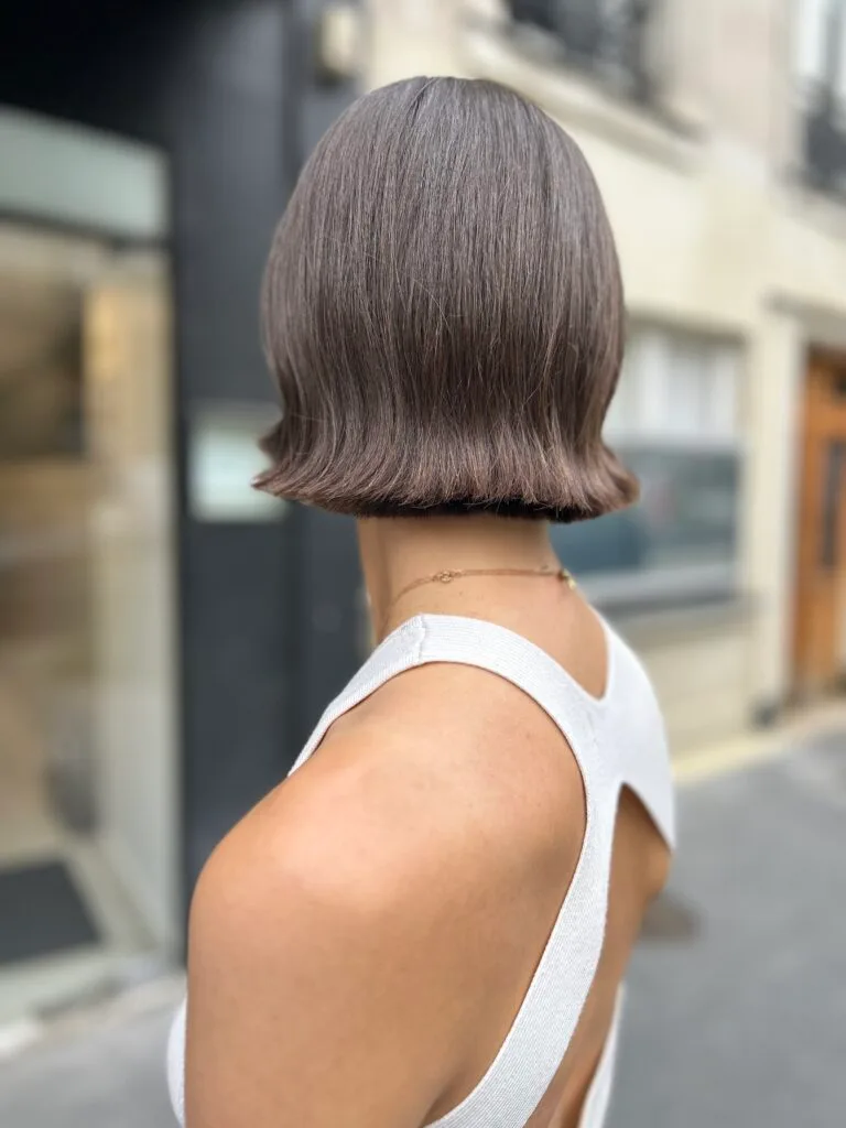 Jeune femme au cheveux brun arborant une coupe bob avec micro frange